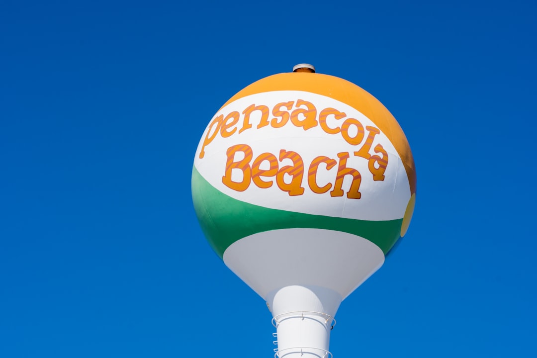 a large orange and white beach ball sitting on top of a white pole